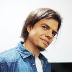 Portrait of Daniel smiling in a denim shirt